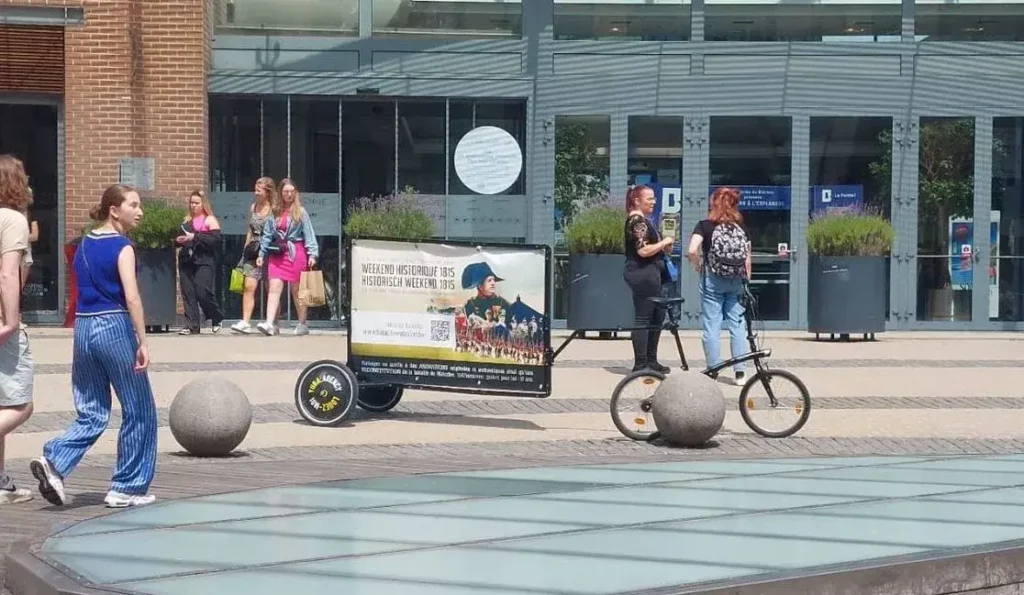 Vélo avec remorque publicitaire dans un espace public