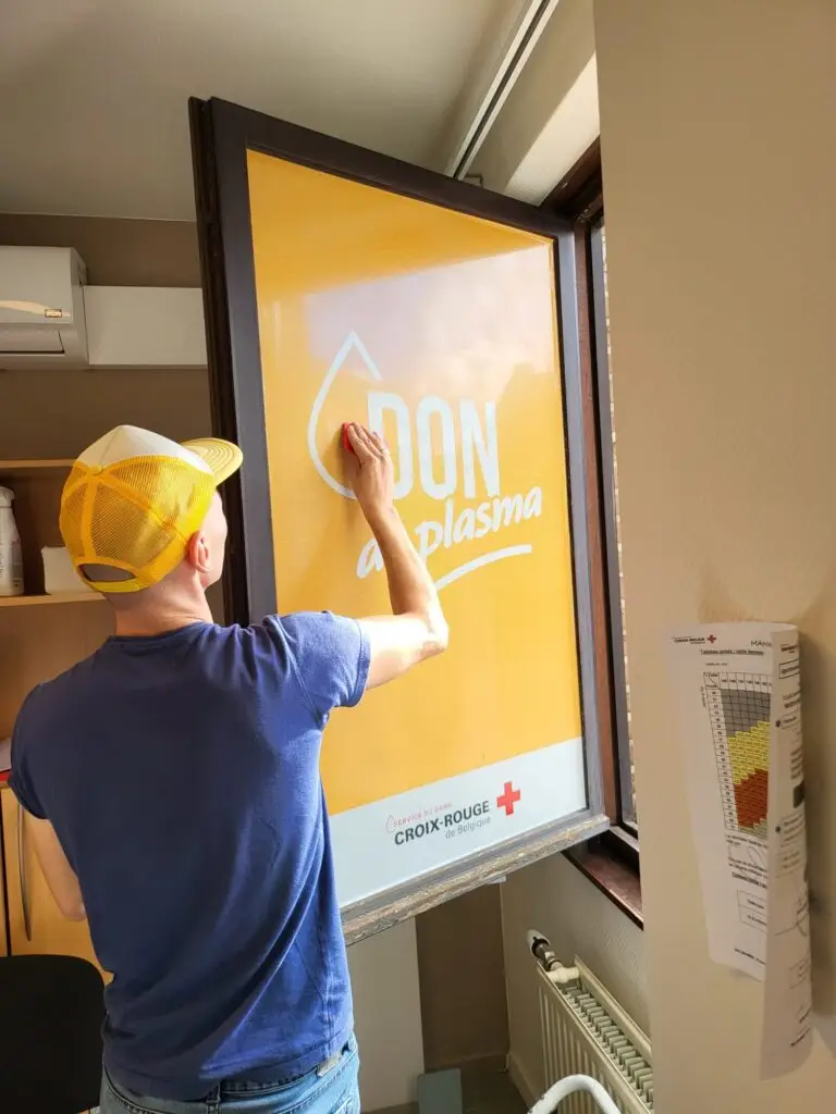 Personne posant une affiche sur une fenêtre