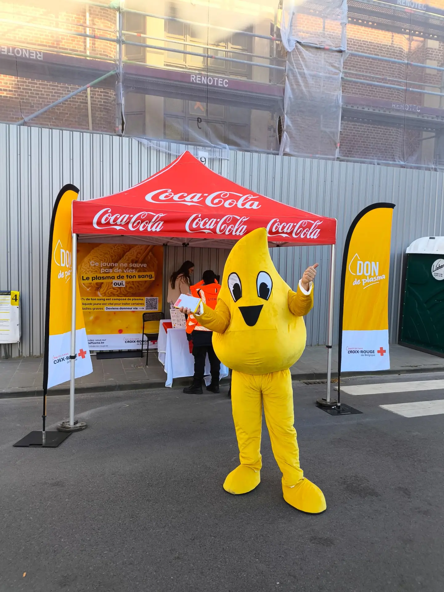 Mascotte Plasma devant un stand de don de la Croix-Rouge