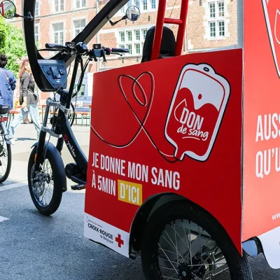Vélo-taxi publicitaire aux couleurs de la Croix-Rouge de Belgique